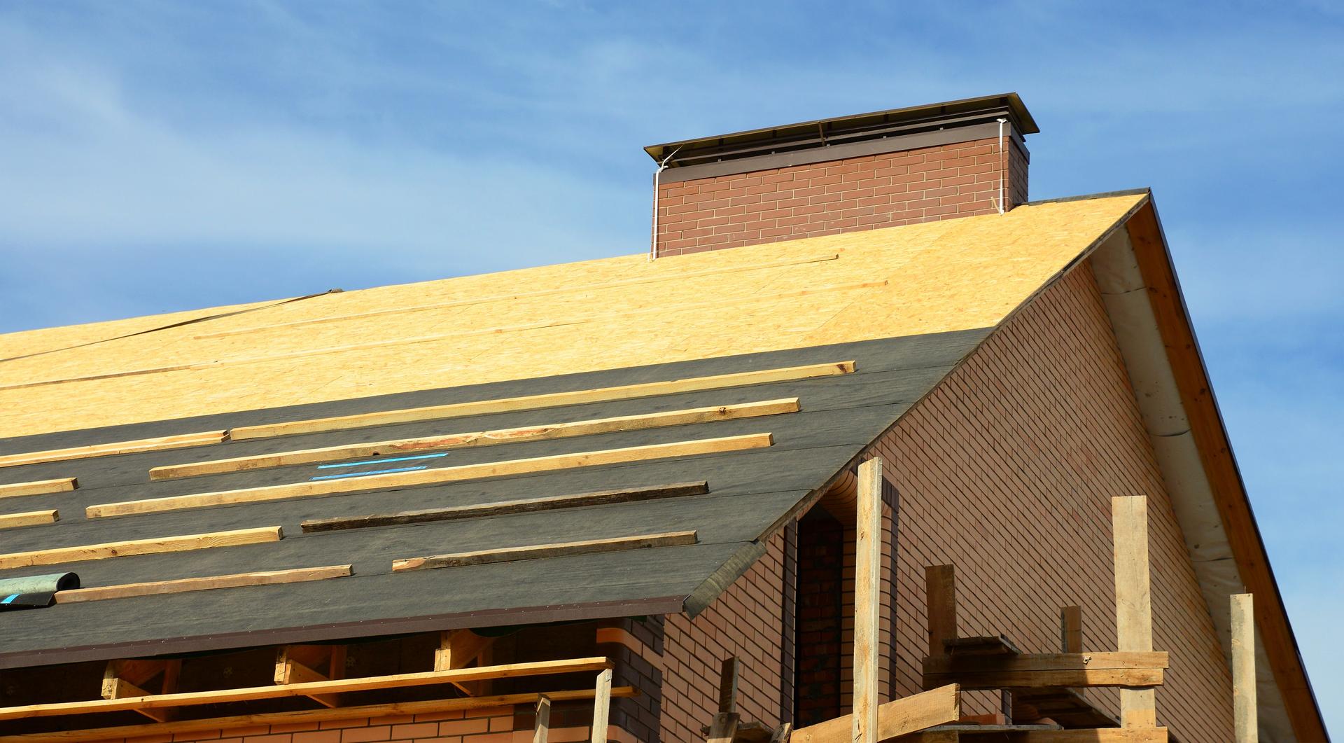 Roofing construction on the stage of roofing underlayment installation on the roof deck, roof sheathing.